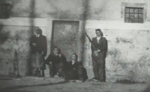Un gruppo di partigiani del distaccamento "Verla" sta facendo la guardia ad alcuni prigionieri tedeschi, catturati in località Masen di Giovo e rinchiusi nell'edificio che serviva di base ai partigiani della zona