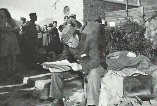 13 maggio 1945 - zona di Bolzano - V armata. Al centro internati di Bolzano, organizzato dal Comitato di Liberazione italiano, questo italiano legge per la prima volta dopo un anno un giornale libero, mentre attende di essere riportato a casa
