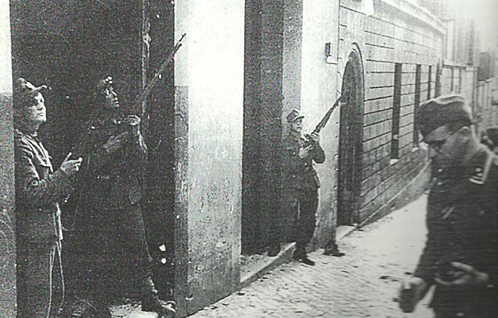 Roma, via Rasella, 23 marzo 1944. Subito dopo l'attentato, soldati del "Bozen" sorvegliano i piani alti della strada, mentre (a destra) un ufficiale del Kds di Roma (Franz Braun) esamina i resti della bomba (Kock, PK 699/BA Koblenz)