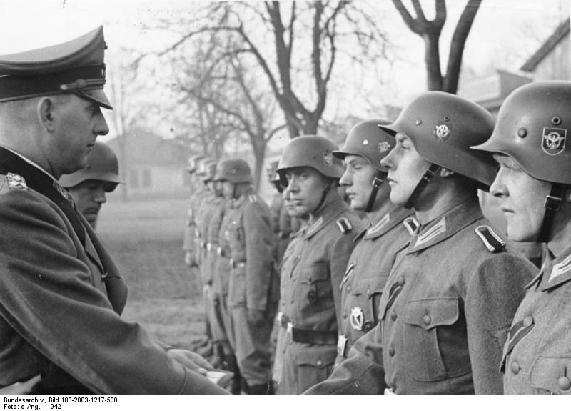 Scherl: SS-Oberst-Gruppenführer und Generaloberst der Polizei Daluege überreicht den Offizieren und Männern des Polizei-Bataillons "Cholm", die der Kampfgruppe Scherer angehörten, den vom Führer verliehenen Cholm-Schild. 7053-42