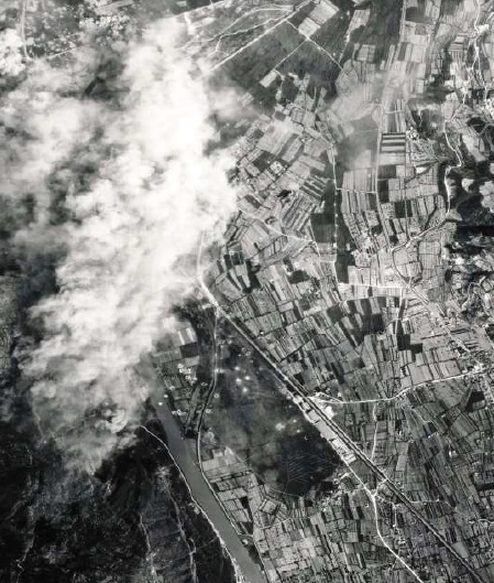 Viadotto dell’Avisio, 19 aprile 1945: aerei del 451° BG lanciano bombe sul bersaglio oscurato dalla nebbia. In basso al centro della foto è visibile il campo di aviazione con i capannoni della Caproni